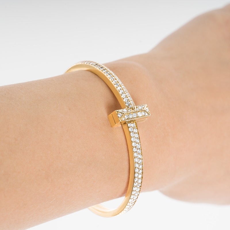 A lady wearing a Tiffany T1 diamond hinged bangle in yellow gold on her wrist